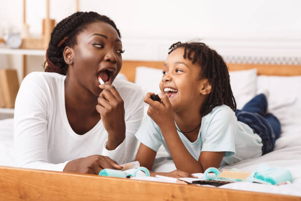 istock Black mom teaching daughter how to do makeup 1190170247
