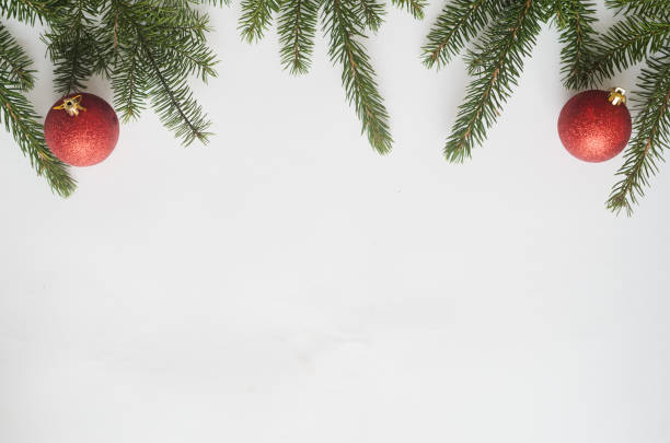 istock Christmas or new year composition.Top view, two red balls and christmas tree branches on white background, copyspace in the down 1190172279