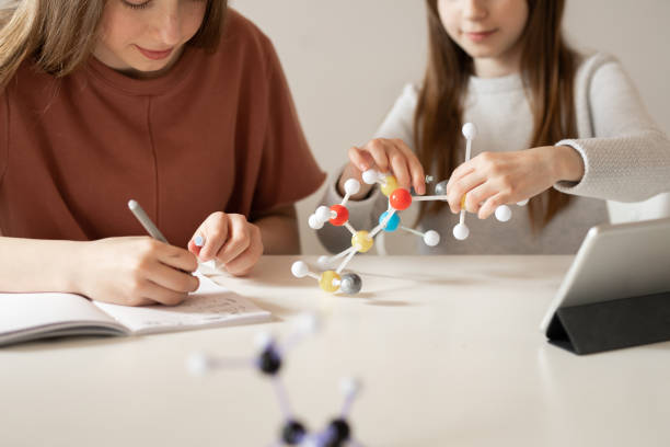 istock Schoolgirls Studying Chemistry Together 1190172430