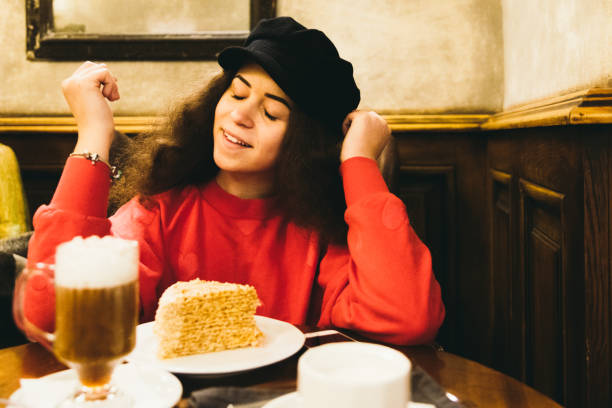 Woman enjoying the cozy winter evening at cafe with coffee and cake
