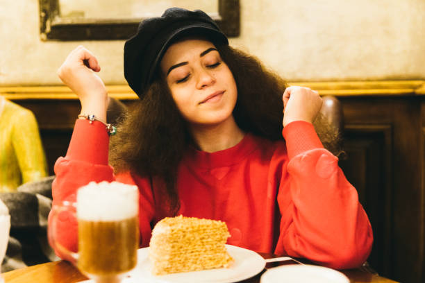 Woman enjoying the cozy winter evening at cafe with coffee and cake
