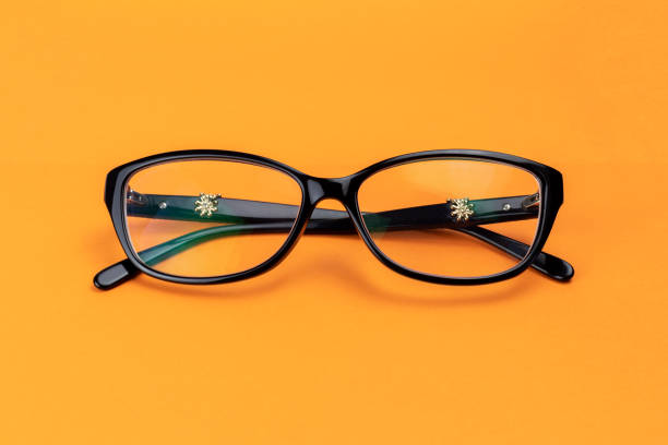 istock Elegant eyeglasses with black frames on an orange background 1190177173
