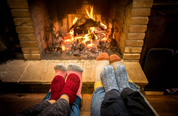 мать отца и детей, сидящих у уютного камина на рождество - прекрасная семья отдыхает вместе на шерстяных носках на месте домашнего огня - зим - log fire стоковые фото и изображения