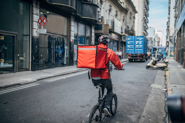 Delivery boy on bicycle in city One man, delivery boy on bicycle, delivering pizza in city. delivery person stock pictures, royalty-free photos & images
