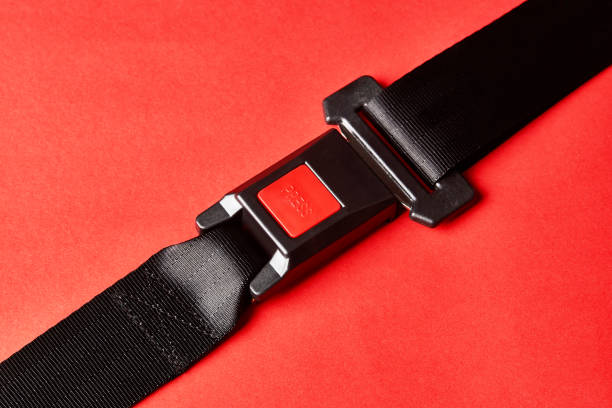 istock Fastened seat belt on red background with copy space, close-up 1190181213