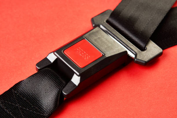 istock Fastened seat belt on red background with copy space, close-up 1190181251