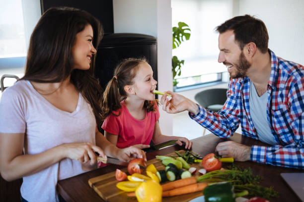 istock Parents and daughter preparing food together 1190183972