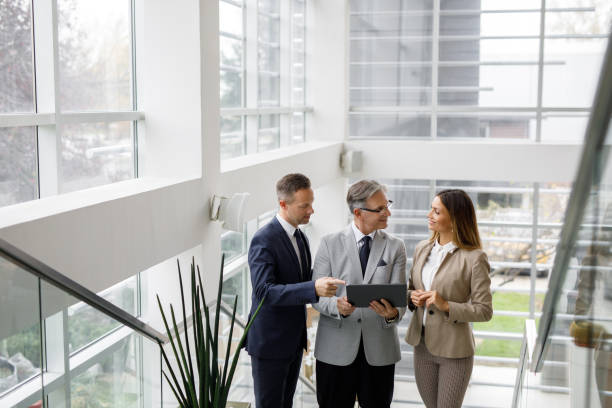 istock Group of mixed aged business people collaborating over digital tablet 1190184780