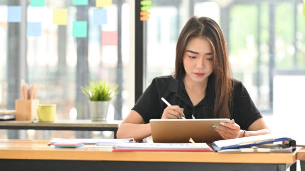 istock Young woman holding tablet on business table. 1190185090