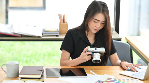istock Young creative woman working with camera and laptop computer. 1190185310