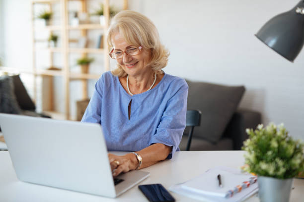 istock Senior woman using laptop at home 1190186849