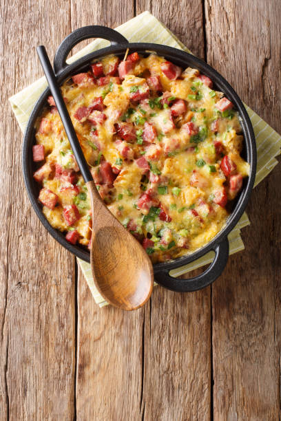istock Traditional american strata with ham, bread, onions, cheese and eggs close-up. Vertical top view 1190188015