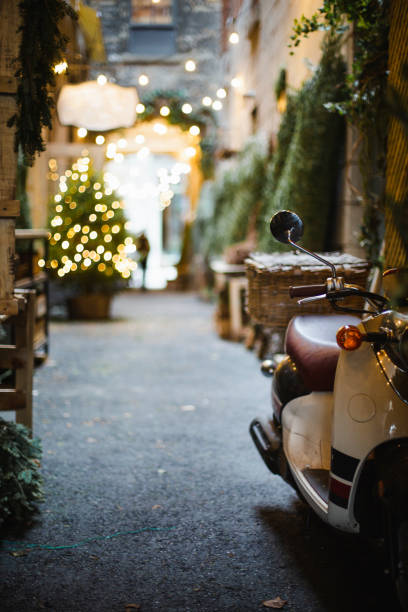 Scooter in flowers near door in small city of Spain with old houses