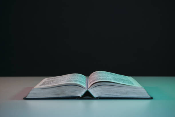 istock Open bible on a  red white table. Beautiful black background. 1190191990