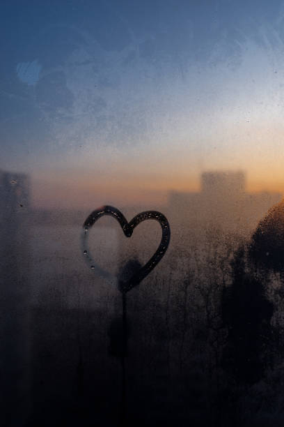 istock Heart shape drawn on moisturized glass window amid the dawn 1190193240