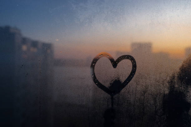 istock Heart shape drawn on moisturized glass window amid the dawn 1190193298