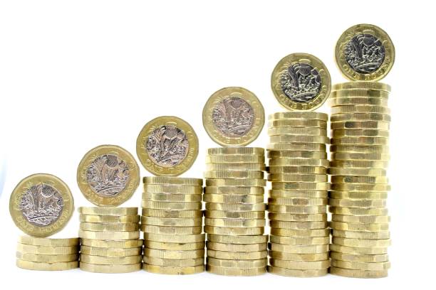 Pound Rising Stacks of ascending UK one pound coins with individual coins balanced on top. one pound coin stock pictures, royalty-free photos & images
