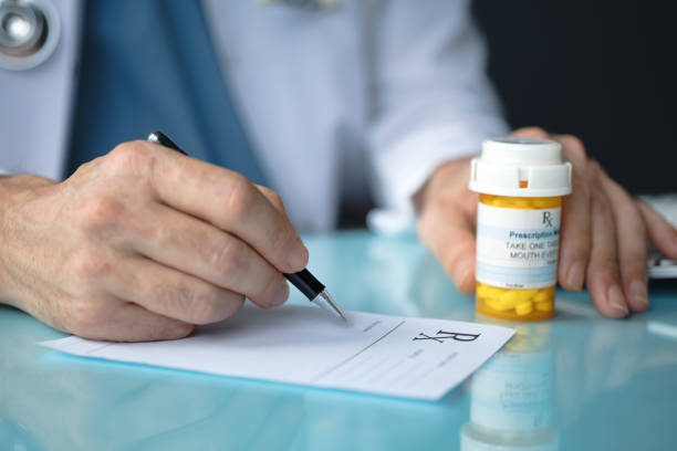 médico llenando una receta - pill bottle fotos fotografías e imágenes de stock