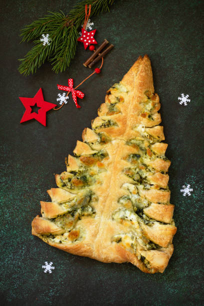 istock Christmas snack menu. Pizza Christmas tree with mozzarella and spinach on a dark tabletop background. Top view of a flat lay. 1190195088