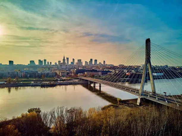 Beautiful panoramic aerial drone sunset view to Warsaw city center with skyscrapers and Swietokrzyski Bridge (En: Holy Cross Bridge) - is a cable-stayed bridge over the Vistula river in Warsaw, Poland