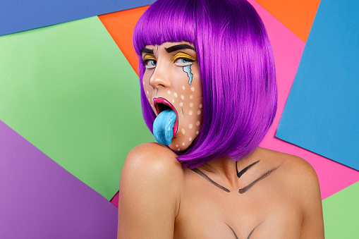 Model in creative image with pop art makeup against colorful background