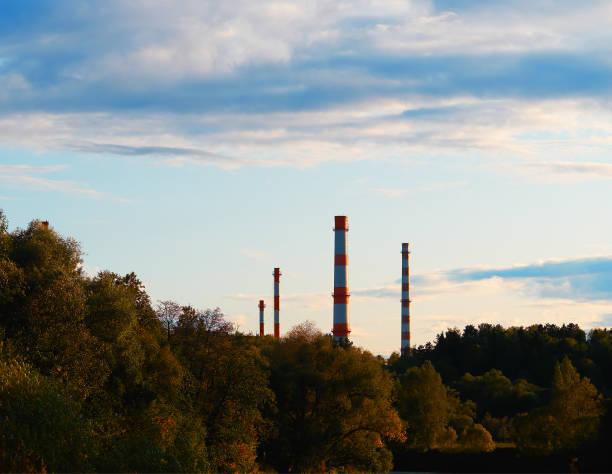 istock Industrial chimneys at autumn forest ecology background 1190199699