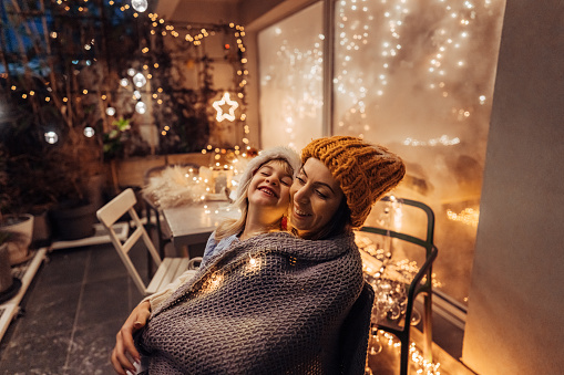 Photo of little girl and her mom enjoying together on the decorated terrace