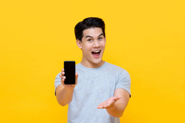 istock Wow excited young Asian man showing mobile phone with open hand 1190202124