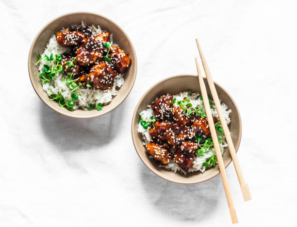 テリヤキソースジューシーチキンキューブライスとマイクログリーン - 白い背景に美味しいアジア風ランチ、トップビュー - herb plant rice white rice ストックフォトと画像