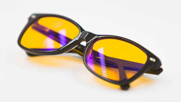 Blue light blocking glasses with yellow lenses and modern trendy stile on white background, health and wellness concept for melatonin and circadian rhythm