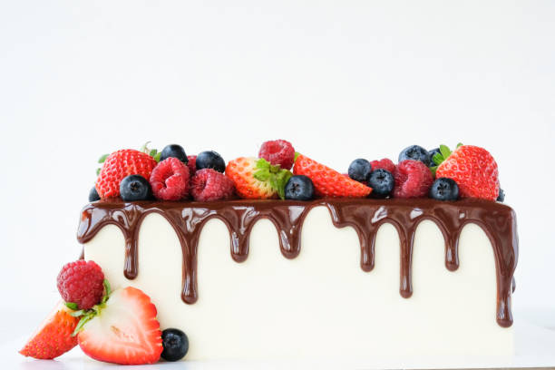 istock Square cake on birthday decorated with fresh berries, poured with chocolate on a white background. 1190208364