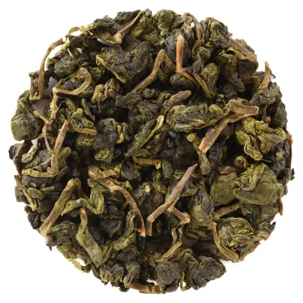 High grade organic dry Taiwanese tea. Meishan Jin Xuan Golden Toad Taiwan Oolong Tea round shaped isolated on white background