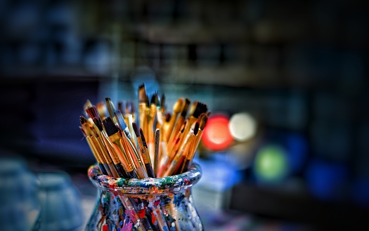 color brushes in jar with  black background