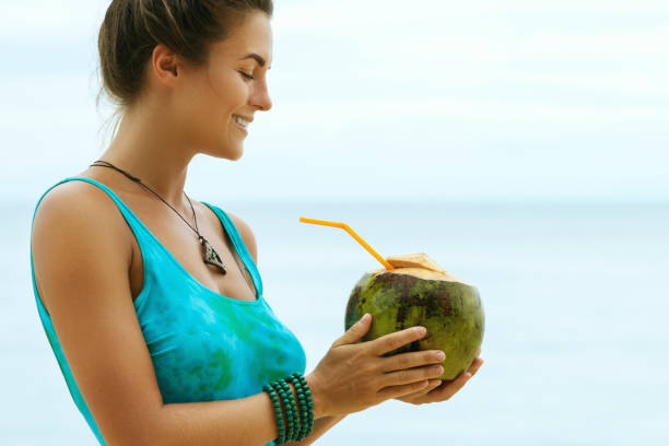 istock Woman with a coconut drink on the beach 1190215785