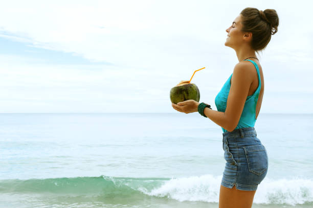 istock Woman with a coconut drink on the beach 1190215834