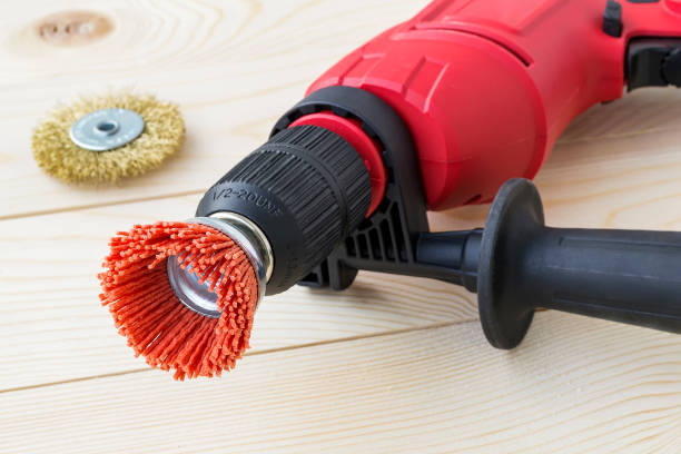 red drill and abrasive brushes with nylon and metal wire on a wooden surface. tools for cleaning, polishing and grinding of wood and metal. - drill red work tool power imagens e fotografias de stock