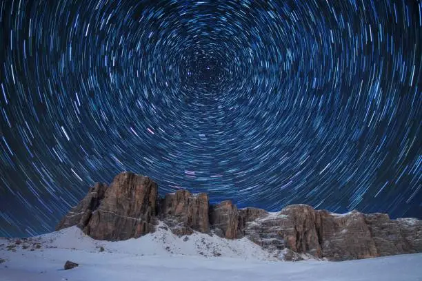 Photo of Winter camping, night, shining green tent on snow. Night shot, long exposure, sleeping on snow in the outdoors.  Alps Mountains landscape panoramic view. Gorgeous winter day in Dolomites, Italy.