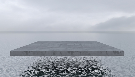 Concrete slab hovers in the air above a smooth surface of the water. Empty cement block flies over the sea or ocean in cloudy weather. Conceptual creative illustration with copy space. 3D rendering.