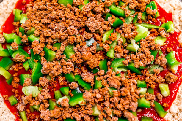 close up superior liso macro da pizza uncooked caseiro com molho de tomate e as pimentas de sino verdes das coberturas desbastadas com carne veganà moída desintegra - chopped green bell pepper pepper bell pepper - fotografias e filmes do acervo