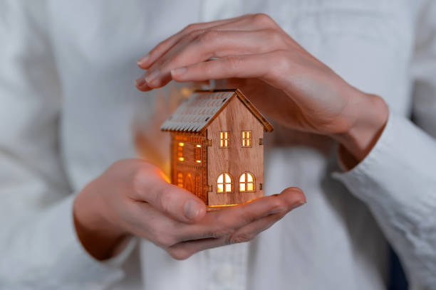concept technology protection of the house from the cold. house in caring female hands stock photo