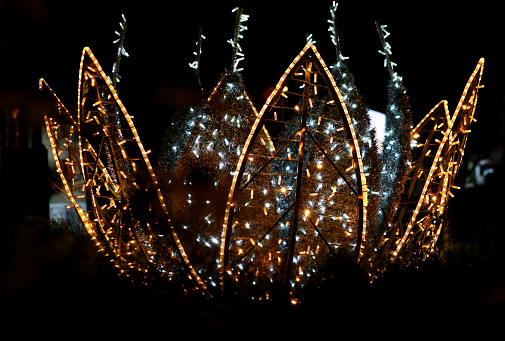 Part of Christmas decorative silver, white, yellow, golden flashing lights. Detail of New Year and Christmas decorations, string rice lights bulbs. Ornaments to christmas celebration, holiday scene.