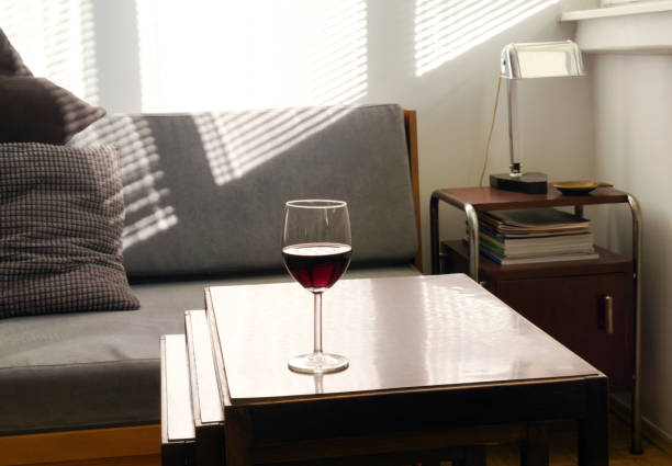 istock Wineglass on table in empty room in afternoon light 1190236557