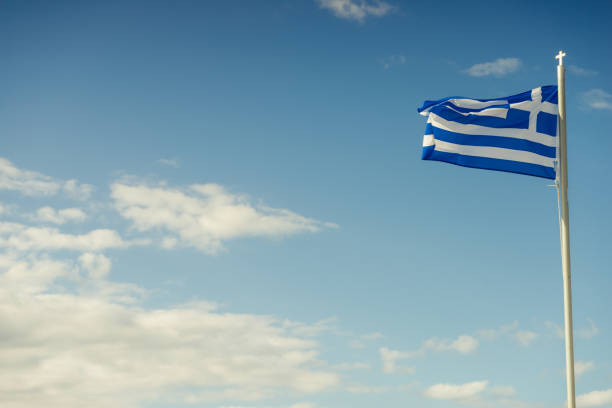 istock Greek flag iwaving against blu sky 1190238051
