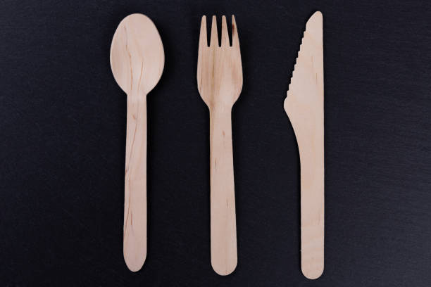istock Wooden fork, knife and spoon on a black rock background. Ecology concept 1190242059