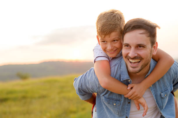 istock A mature father standing and holding a toddler son, having fun. 1190246611
