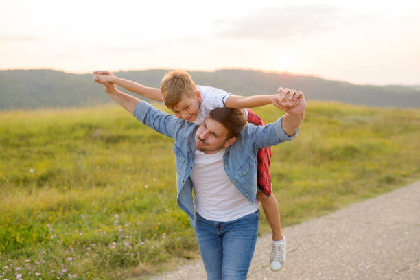 istock A mature father standing and holding a toddler son, having fun. 1190246616