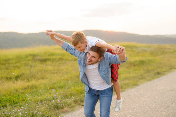istock A mature father standing and holding a toddler son, having fun. 1190246618