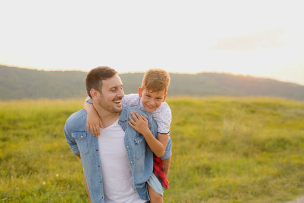 istock A mature father standing and holding a toddler son, having fun. 1190246620