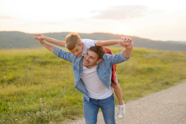 istock A mature father standing and holding a toddler son, having fun. 1190246622