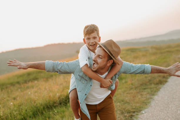 istock A mature father standing and holding a toddler son, having fun. 1190246655